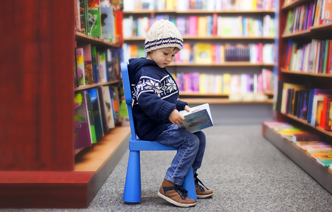 Young child reading in library